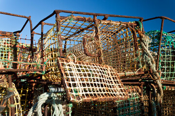 Pile of crab fishing pots on the waterfront of fishing port - obrazy, fototapety, plakaty