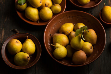 pears in ceramic bowls on a dark background