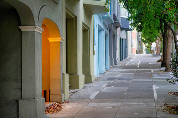 Lone light in a row of building entrances on a side walk and a row of trees in the downtown city neighborhood of san francisco