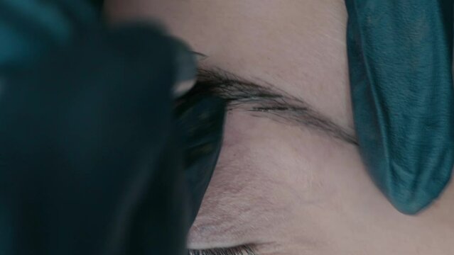 Slow motion video recording of microblading work. Permanent makeup on the eyebrows for a young woman.
