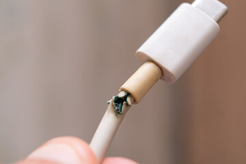 Close-up of the broken white Type-C charger cable to the phone. USB cable is damaged.