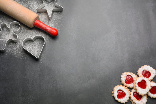 Christmas cookies sprinkled with powdered sugar, cooking molds and rolling pin. Flat lay, place for text