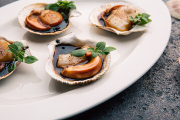 Scallop in sauce garnished with herbs