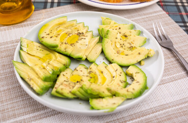 ripe avocado pulp cut into pieces sprinkled with lemon juice on a plate