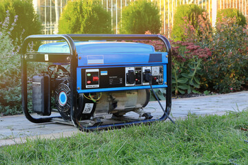 Power generator standing in the garden on the pavement.
Agregat prądotwórczy stojący w ogrodzie na chodniku. - obrazy, fototapety, plakaty