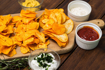 Tortilla chips on a cutting board and dipping sauce