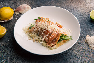 Salad with arugula, salmon, tomatoes, garnished with cheese and pine nuts