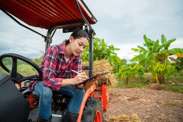 Asian Female agronomist using tablet modern technology in agriculture. Agricultural technology concept.