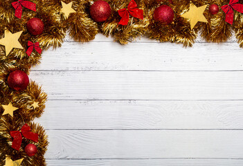 Fototapeta na wymiar Decorative Christmas golden garlands, christmas balls and wooden stars on wooden white background. Flat lay, top view, copy space