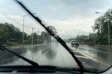 Car wipers clean windshields when driving in sunny weather, driver drives the car on a rainy day.