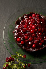 Chocolate dessert with lingonberry jam and a twig with berries
