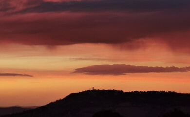 Rosso tramonto sul paese sopra la collina