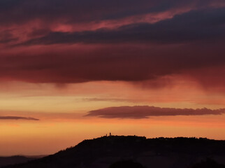 Rosso tramonto sul paese sopra la collina
