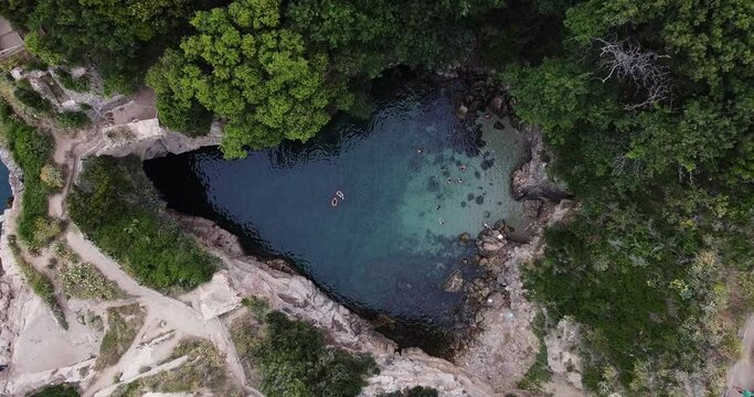 People swimming in a hidden beach. Bagni di Regina Giovanna, Sorrento, Italy. Blue lagoon cave beach for tourists, in summer with blue water. Cave rocky beach . High quality FullHD footage