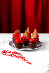 christmas cupcakes on plate with red cream on white table