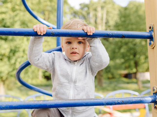 little boy playing on the playground outdoors