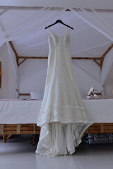 Fototapeta na wymiar wedding dress hanging on the bed 