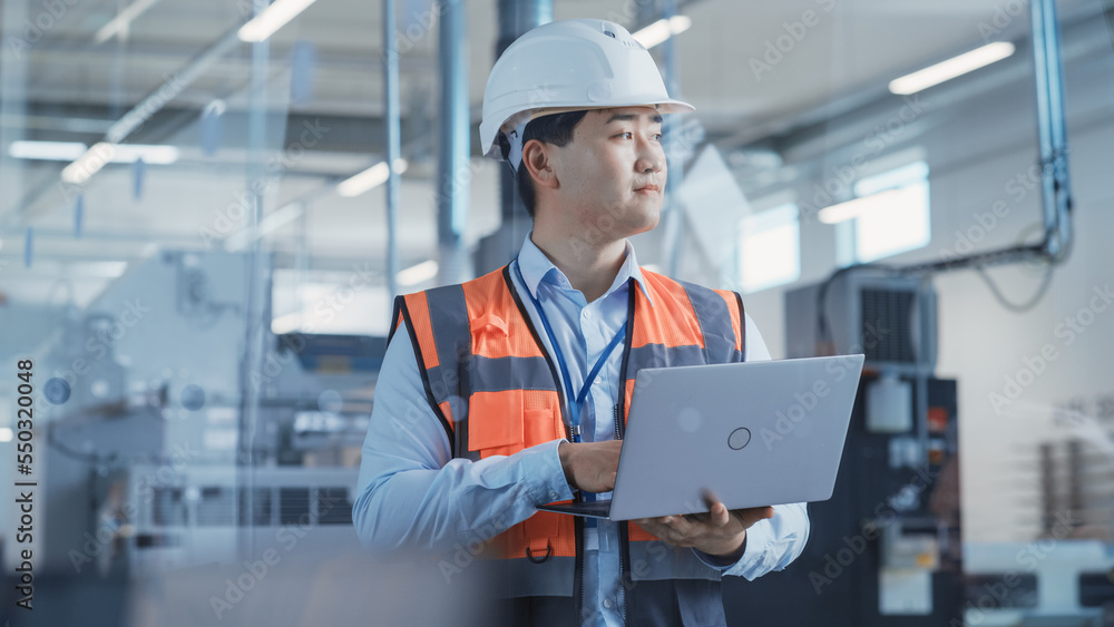Poster portrait of an asian male engineer in orange safety vest working on laptop computer at electronic ma