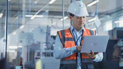 Research and Development Specialist Using Laptop to Operate a Heavy Industry Machine at a Factory....