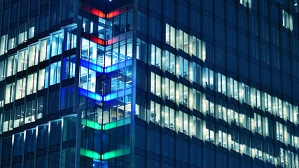 Plakat Pattern of office buildings windows illuminated at night. Glass architecture ,corporate building at night - business concept. Blue graphic filter.