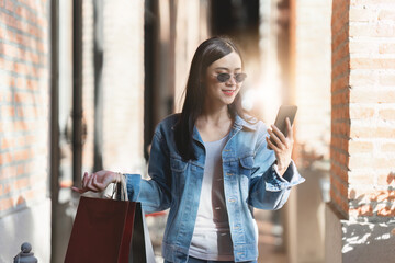 Asian fashionable woman walking at shopping mall with shopping bags while flash sale promotion