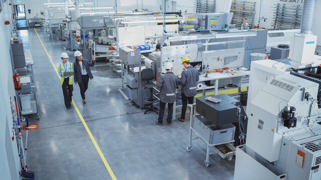 Industrial Factory: Diverse Multiethnic Team of Engineers, Technicians, Specialists and Workers, Working on Production Plant, Developing CNC Parts, Programming Machines, Executing Orders. © Gorodenkoff