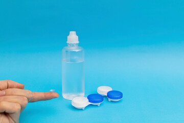 Girl holding an eye contact lens on her finger, optical advertising shot