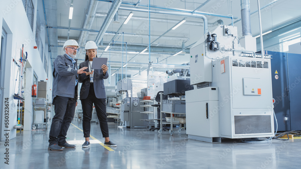 Aufkleber portrait of two heavy industry employees in hard hats at factory. checking and discussing industrial