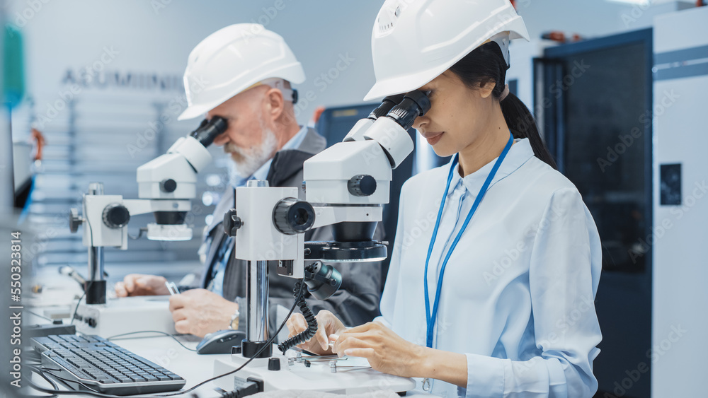 Poster Modern Technology Concept: Two Scientists Examining Small Scale Industrial Equipment Parts Through a Microscope. Technicians Testing New Factory Components for Quality.