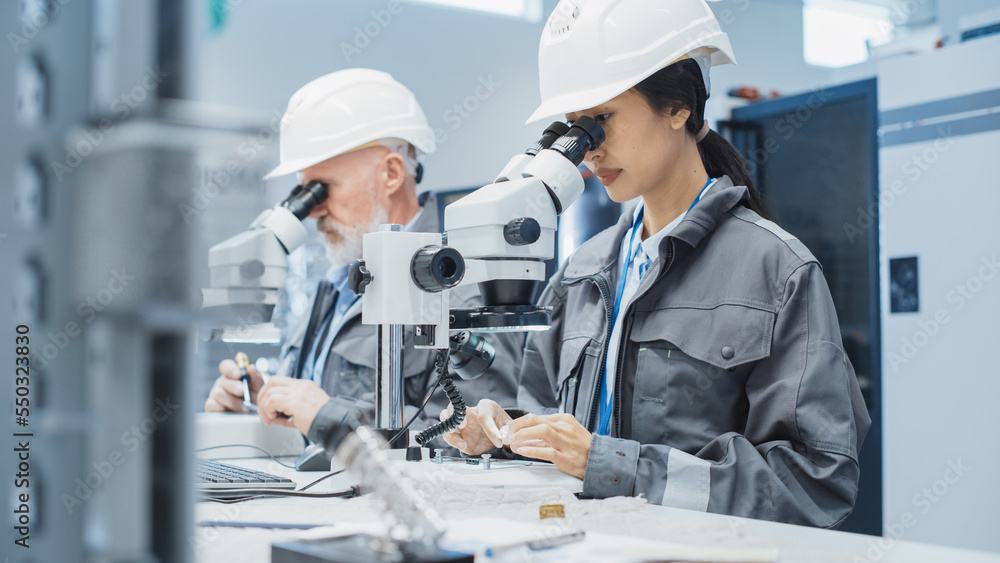 Poster electronic manufacturing factory: two engineers examining small scale industrial equipment parts thr
