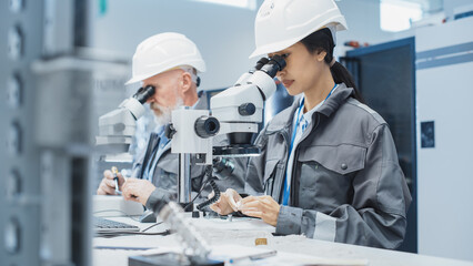 Electronic Manufacturing Factory: Two Engineers Examining Small Scale Industrial Equipment Parts...