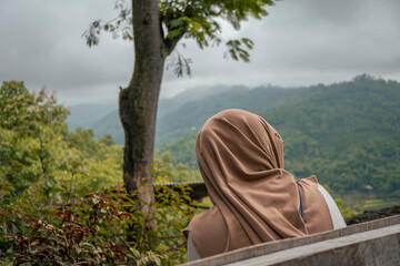 The Women stand alone looked to the forest and valley. The photo is suitable to use for traveler background and holiday poster.