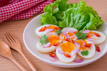 Spicy boiled eggs salad on white plate.