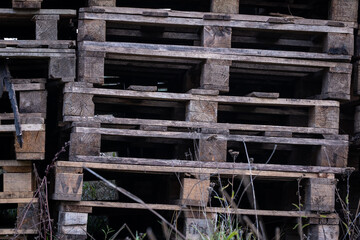 Fototapeta na wymiar stacked old wooden palettes. Wooden industrial background