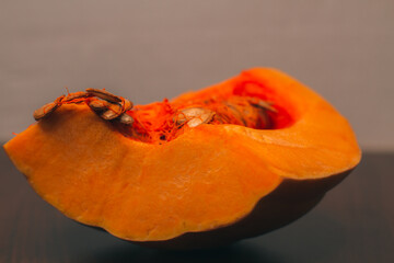 Pumpkin isolated on a dark background. Pumpkin seeds. Autumn vegetable harvest. Vegetables background. Cooking dinner. A piece of sweet pumpkin for making a pie. American food