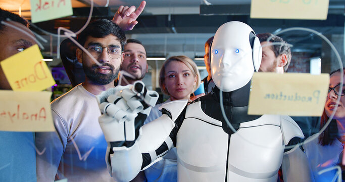 Team of startup planning future tasks in office with humanoid. People and artificial intelligence discussing work and project. Brainstorming meeting. Management strategy. Digital transformation