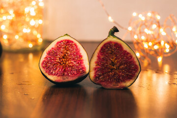 Fig halves, close-up. Golden Christmas lights. An ingredient for making a delicious dessert with figs for the winter holidays. Sweet figs. Recipes of the cuisines of the world