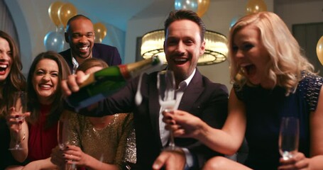 Party, champagne and new year with a friends popping a cork or pouring alcohol into glasses together. Event, birthday and celebration with a man and woman group having fun, drinking or being social