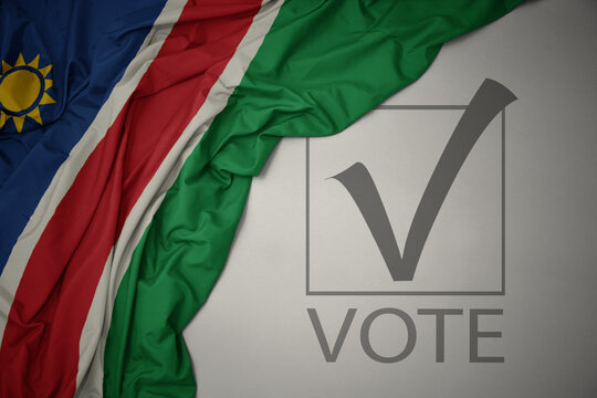 waving colorful national flag of namibia on a gray background with text vote. 3D illustration