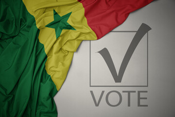 waving colorful national flag of senegal on a gray background with text vote. 3D illustration