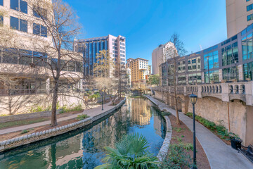 Canal flanked by pathways on a sunny day in San Antonio River Walk Texas