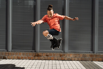 Focused man in roller blades doing trick on city street.