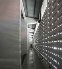 The sunlight shines through light channels wall of old gymnasium. Concrete walls have holes for sunlight to penetrate through the holes from the outside, Light and shadow concept, Space for text, Sele