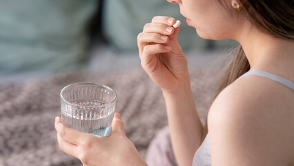 Woman holding pill in hand with water.Health concept 