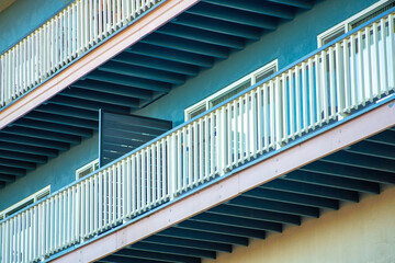 Large and endless balcony with white hand rails on the exterior of downtown building in the city neighborhoods in city