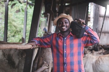 African farmer holding vintage radio listening to music and listening to radio news on his cattle farm