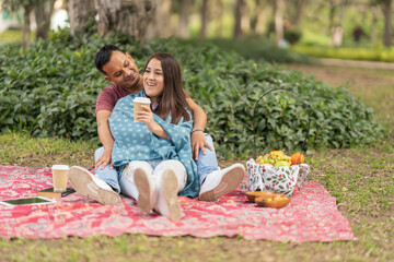 Happy couple having picnic in park