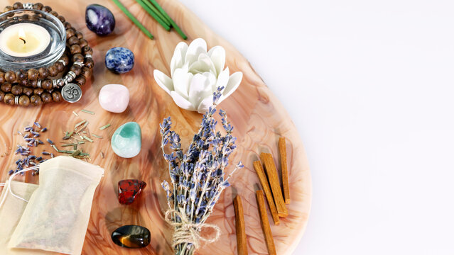 Self-care, energy healing composition with rosary beads, aroma sticks, chakra stones, sandalwood sticks and candle on pink marble podium with copy space. Concept of relaxing at home, meditation, yoga