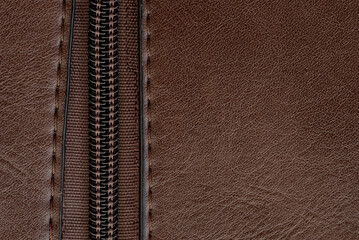 Zip closure on a brown leather bag. Texture with a lock with a zipper
