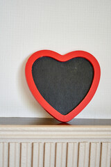 chalkboard  with red heart shape frame on top wood panel